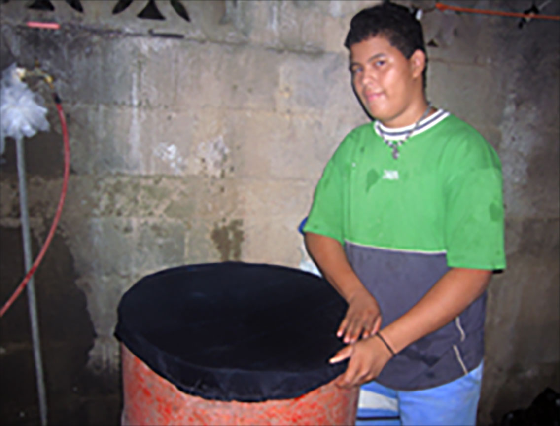 A person covering a rain barrel with netting.